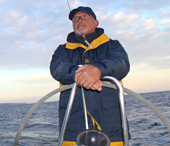 Segellehrer Wolfgang Krause am Steuerrad einer Segelyacht