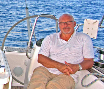 Segellehrer Wolfgang Krause am Steuerrad einer Segelyacht